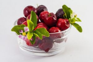 Acerola fruits in a ball with some leaves