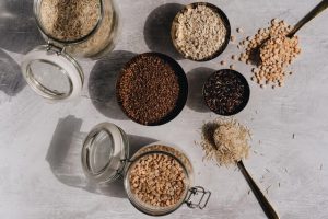 different cereals in glass jars and spoons