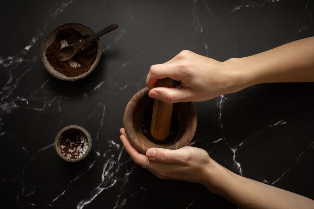 preparing coffee face scrub by grinding it