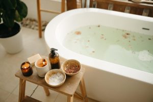 Relaxing bath with bath salts and cosmetics on a side table