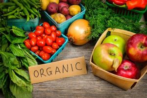 fruits and vegetables with a piece of cardboard with "Organic' written on it