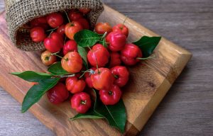 Wooden board with acerola fruits on it